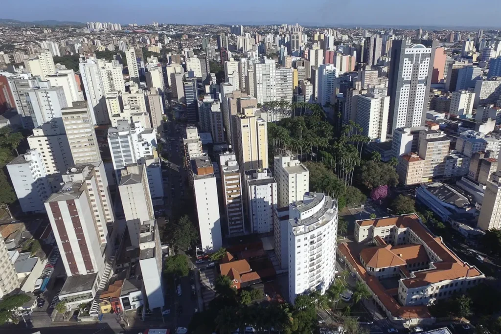 Vista panorâmica de Belo Horizonte com prédios altos, áreas verdes e horizonte urbano que se estende até as montanhas