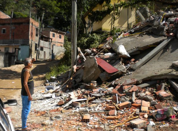 Deslizamento de terra em São Gonçalo, com detritos de construções bloqueando a via.