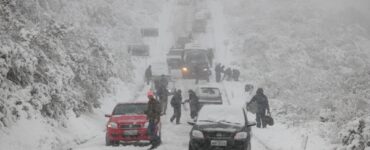 Neve encobrindo estrada e carros