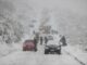 Neve encobrindo estrada e carros