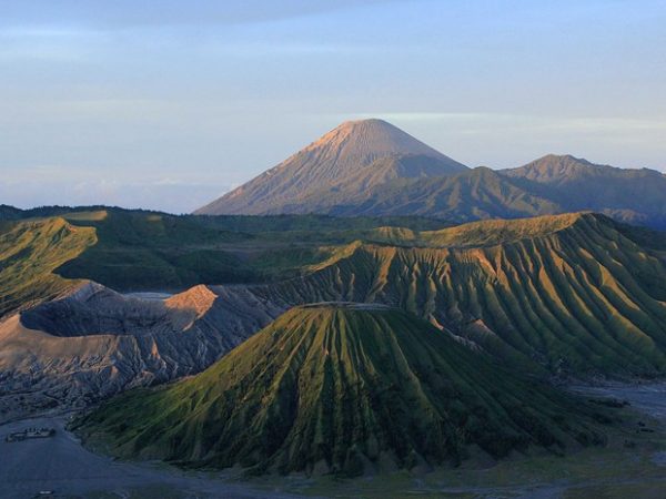 Imagem do vulcão Bromo, na ilha de Java, coberto por vegetação rala. Esse vulcão foi formado pela erosão por água da chuva, um de seus principais agentes.