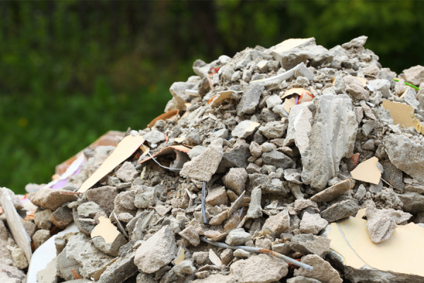 Foto de uma pilha de resíduos sólidos de construção civil, com pedras, pedaços de metal e outros.