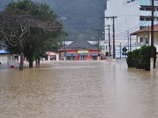 Foto de enchentes em Santa Catarina, cobrindo toda a rua.