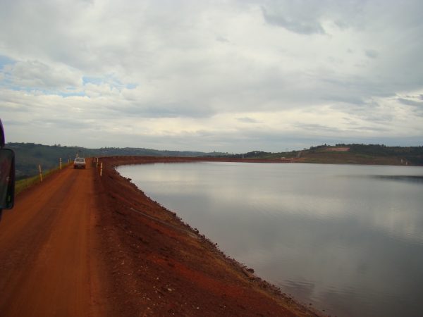 Foto de uma barragem de rejeitos em Minas Gerais, com um lago ao lado.