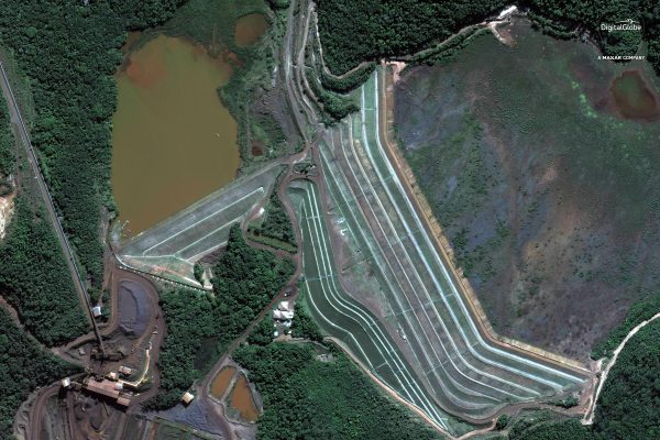 Foto aérea de uma barragem, com seus alteamentos.