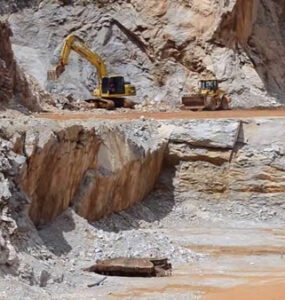 Foto de uma lavra com uma escavadeira