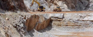 Foto de uma lavra com uma escavadeira