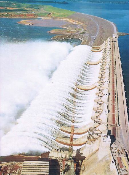 Foto do vertedouro da UHE Tucuruí, com água jorrando das comportas da barragem.