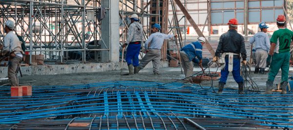 Foto de trabalhadores aplicando o concreto protendido em obra de construção civil.