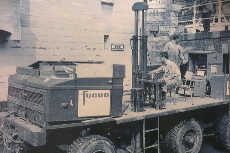 Foto sépia de um homem dirigindo um maquinário da FUGRO.