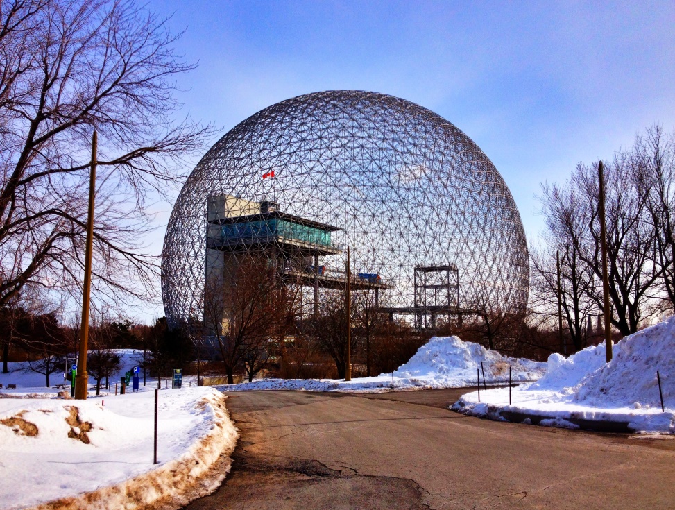 Foto da Biosfera de Montreal, grande estrutura redonda, com neve ao seu redor. É uma das maiores cúpulas geodésicas do mundo.