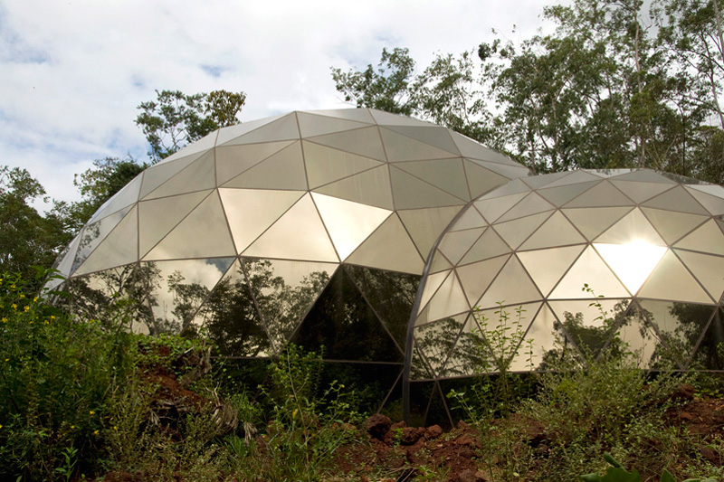 Foto dos domos geodésicos do Centro de Arte Contemporânea Inhontim, em Brumadinho, que tem cobertura em vidros reflexivos.