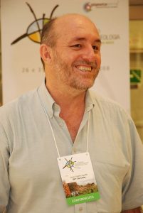 Foto do prof. Lázaro Zuquette, homem branco, careca, com uma blusa clara de botão e sorrindo.
