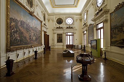 Foto do interior do Museu Paulista, com quadros e objetos dispostos numa sala.