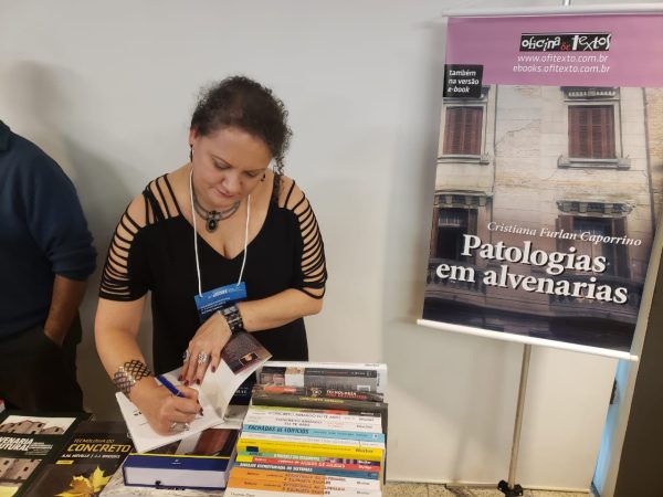 Cristiana Furlan autografando cópias de Patologias em alvenarias em um evento. 