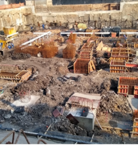 Fôrmas de madeira para concreto sendo utilizadas em canteiro de obras para moldagem de fundações estruturais com armaduras de aço aparente.