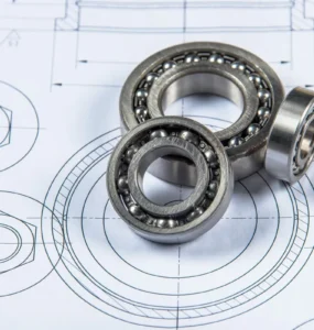 Rolamentos de esferas metálicos posicionados sobre desenho técnico de engenharia mecânica com vista detalhada em planta.