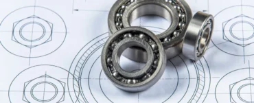Rolamentos de esferas metálicos posicionados sobre desenho técnico de engenharia mecânica com vista detalhada em planta.