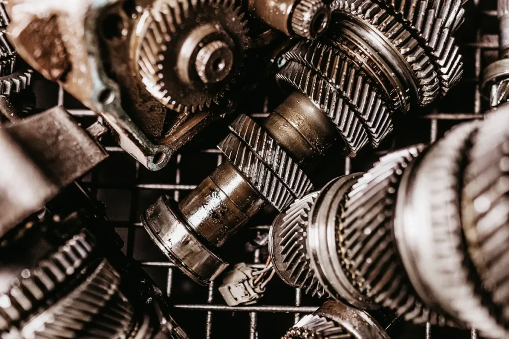 Conjunto de engrenagens metálicas lubrificadas em close-up, usadas em sistemas de transmissão mecânica.