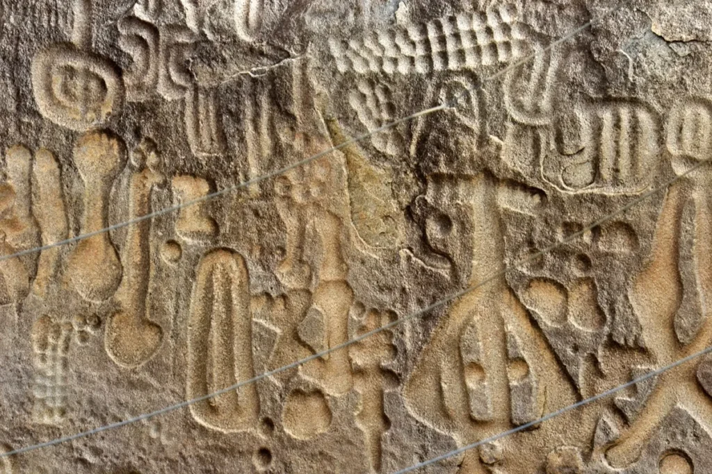 Close-up dos símbolos rupestres entalhados na Pedra do Ingá, na Paraíba, com formas geométricas, abstratas e enigmáticas gravadas na rocha.