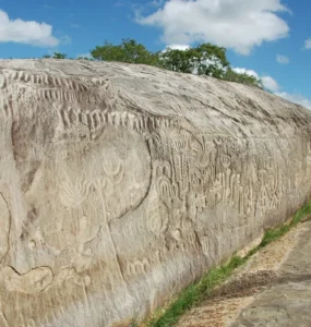 Inscrições rupestres entalhadas na Pedra do Ingá, um grande rochedo na Paraíba, com símbolos geométricos e abstratos gravados na superfície.