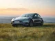 Tesla Model 3 preto estacionado em campo aberto durante o pôr do sol, simbolizando inovação, sustentabilidade e mobilidade elétrica