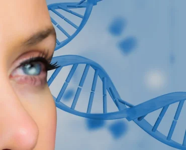 Close no rosto de uma mulher com olhos azuis em primeiro plano, ao fundo representação de hélice de DNA em cor azul.