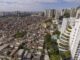 Vista aérea mostrando contraste entre favela densamente ocupada e edifícios de alto padrão em São Paulo.