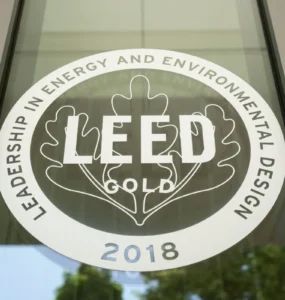 Selo de certificação LEED Gold 2018 em vidro, representando construções sustentáveis e eficiência ambiental