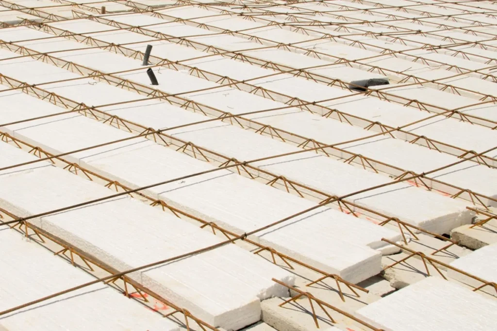 Estrutura de laje pré-moldada com blocos de EPS e malha de ferro antes da concretagem.