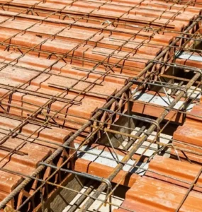 Laje pré-moldada com vigotas de concreto e blocos cerâmicos, mostrando armação de ferro na construção.
