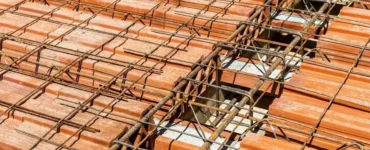 Laje pré-moldada com vigotas de concreto e blocos cerâmicos, mostrando armação de ferro na construção.