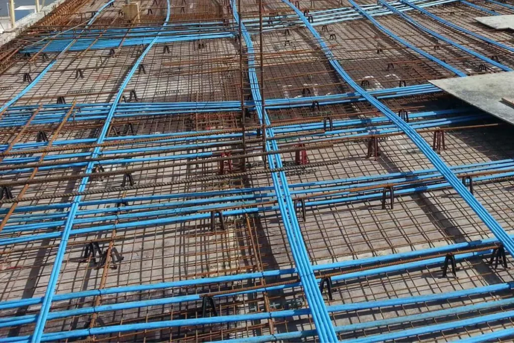 Estrutura de laje com cabos azuis de protensão e armaduras de aço montadas antes da concretagem