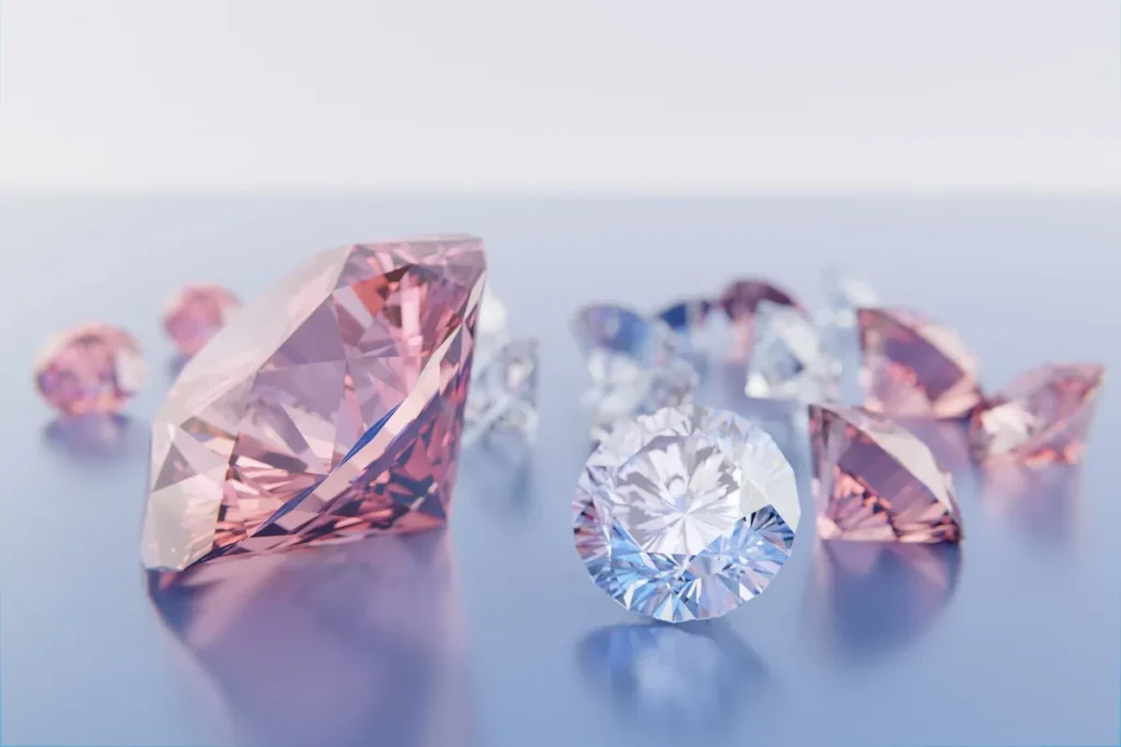 Diamantes lapidados em tons rosa e transparente dispostos sobre superfície clara, destacando brilho, facetas e variação de cores.