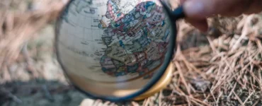 Lupa ampliando mapa da Europa e África em globo terrestre, representando estudo geográfico e análise territorial