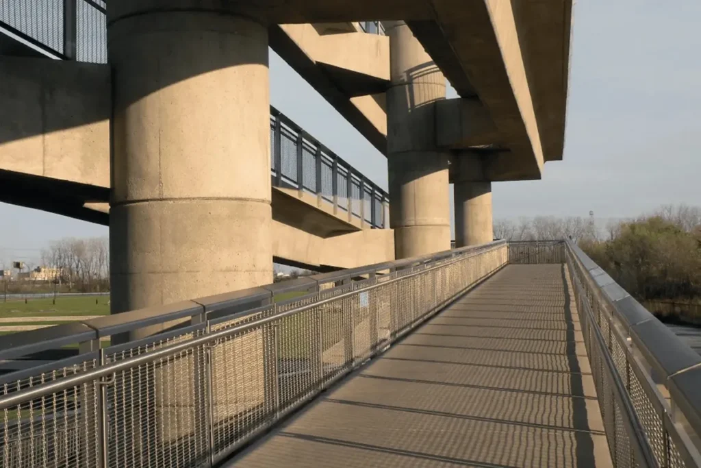 Pilares de concreto sustentando viaduto e passarela metálica em estrutura urbana moderna