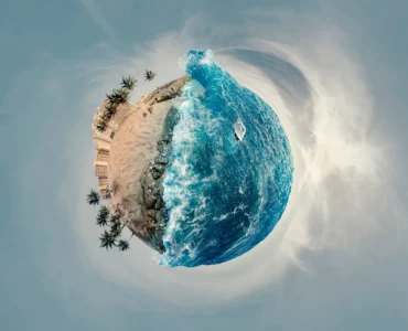 Efeito Little Planet mostrando uma praia com palmeiras e mar azul formando um mini planeta em imagem panorâmica 360 graus.