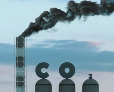 Chaminé industrial liberando fumaça com estruturas metálicas ao lado formando a palavra CO2.