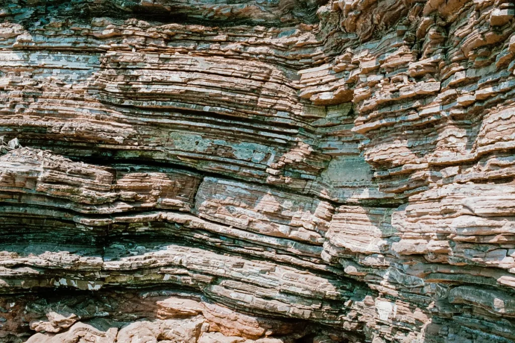 Formações rochosas com várias camadas horizontais expostas em um paredão natural.