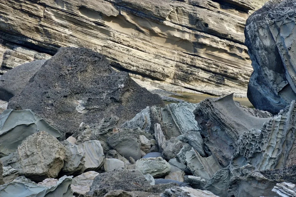 Grandes blocos de rochas e camadas geológicas visíveis em uma área de formação natural.