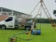 Equipamento de sondagem de solo montado em campo com técnico operando próximo a caminhão